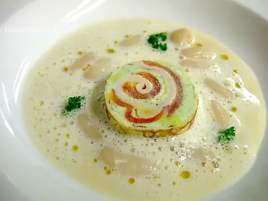 Cremesuppe von kleinen weißen Bohnen mit einer Frischkäseroulade von Basilikum mit Bauchspeck und Tomaten