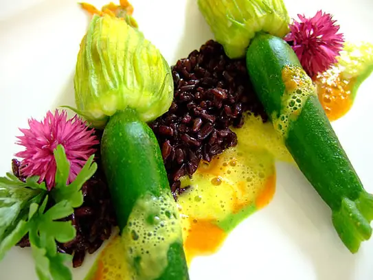 Gedämpfte Zucchiniblüten gefüllt mit Gemüsekuskus auf Venere Reis