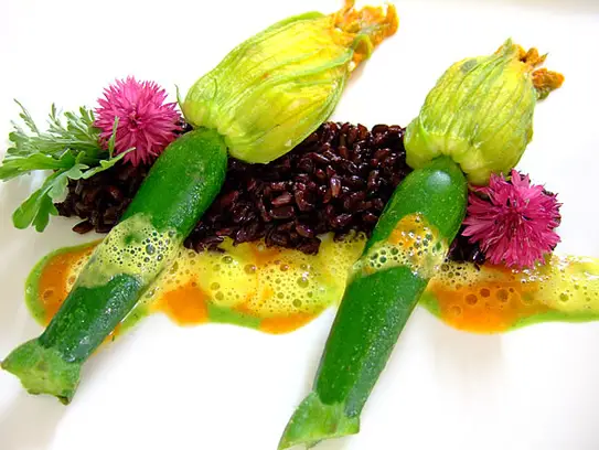 Gedämpfte Zucchiniblüten gefüllt mit Gemüsekuskus auf Venere Reis
