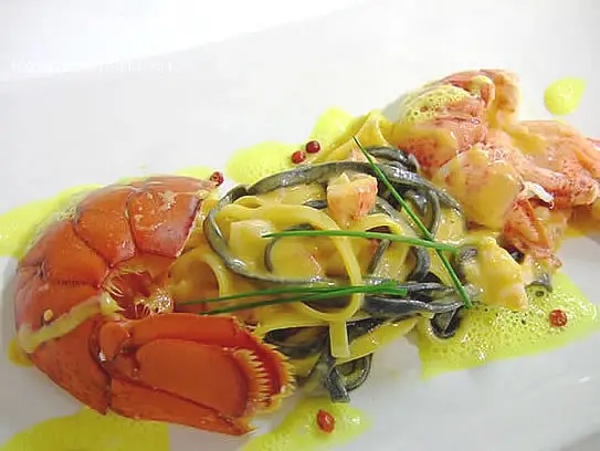 Schwarze und weiße Bandnudeln in Hummerrahmsauce mit rosa Pfefferkörner