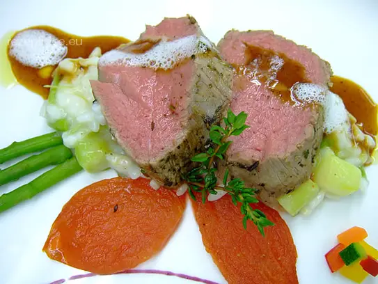 Im Ganzen rosa gebratenes Kalbsfilet auf Spargelrisotto mit Ofentomaten