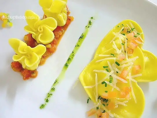 Teigtaschen mit Käsefüllung und Butter abgeschmolzen auf sautierten Tomatenragout