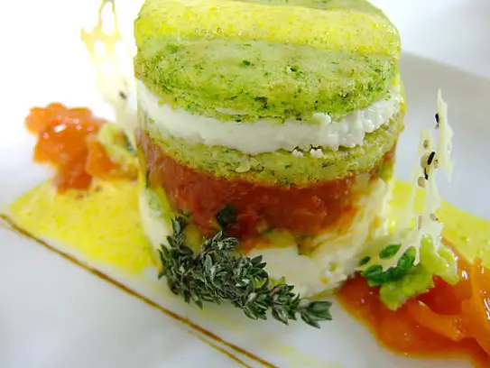 Kräuterflan mit Zucchini und Tomaten mit Safranschaum auf sautierten Kirschtomaten