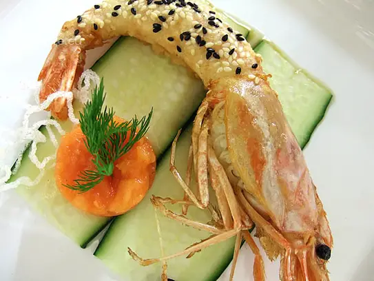 Riesengarnele in Tempura-Sesammantel frittiert auf Gurkenbeet mit Avocadotartare