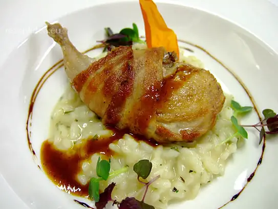 Risotto mit frischen Kräutern und gebratenem Wachtelbrüstchen im Bauchspeckmantel