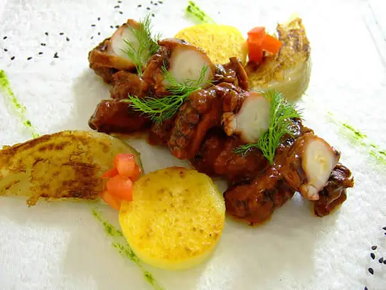 Krake in Tomaten geschmort auf Polenta und Fenchel