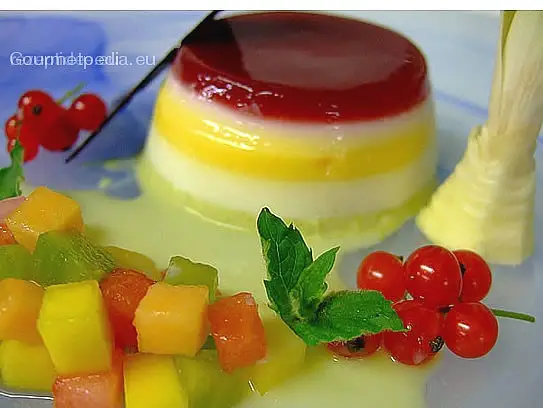 Gekochte Sahne mit Himbeergelee und Pistazien auf marinierten exotische Früchten