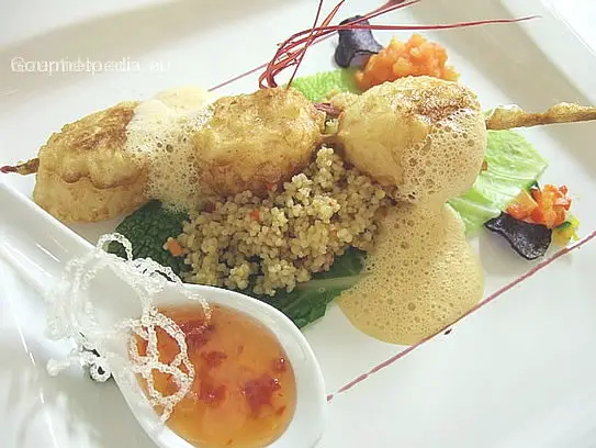 Spießchen von Jakobsmuscheln in Tempura gebacken auf Gemüsekuskus und Hummerschaum