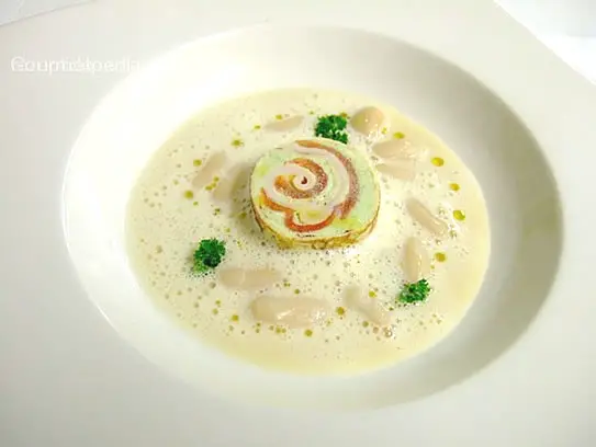 Cremesuppe von kleinen weißen Bohnen mit einer Frischkäseroulade von Basilikum mit Bauchspeck und Tomaten