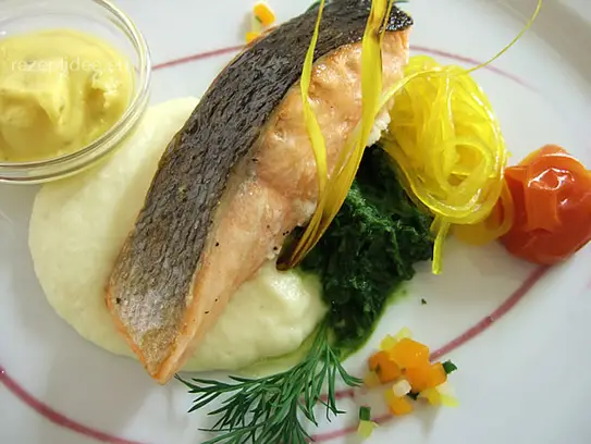 Gegrillte Lachsschnitte auf Selleriepüree, sautierten Spinat und Safrannudeln