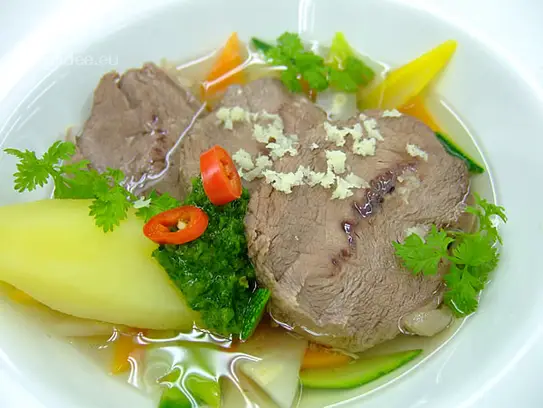 Im Wurzelgemüsesud pochiertes Kalbsschulternathl mit grüner Kräutersauce und Naturkartoffeln