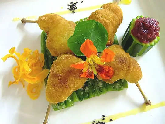 Gefüllte frittierte Wachtelkeulen auf grünen Bohnen und gedünsteten Blaukraut in der Zucchini