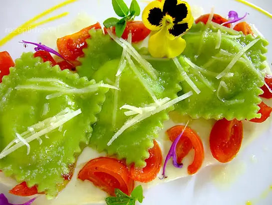 Grüne Teigtaschen mit Spinat-Mascarponefüllung auf Käsesauce